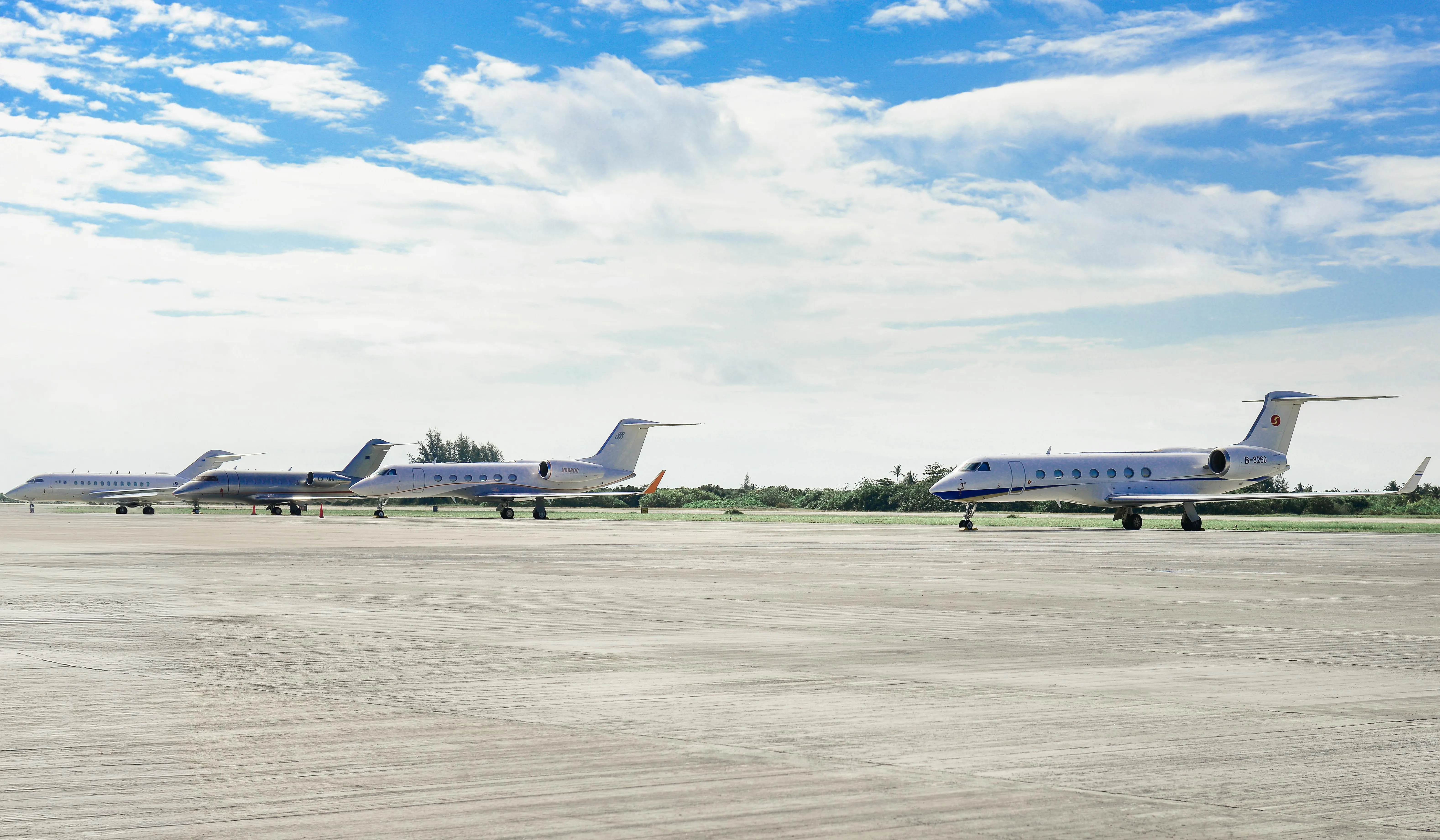 Business aircraft lined up on a wide airport ramp