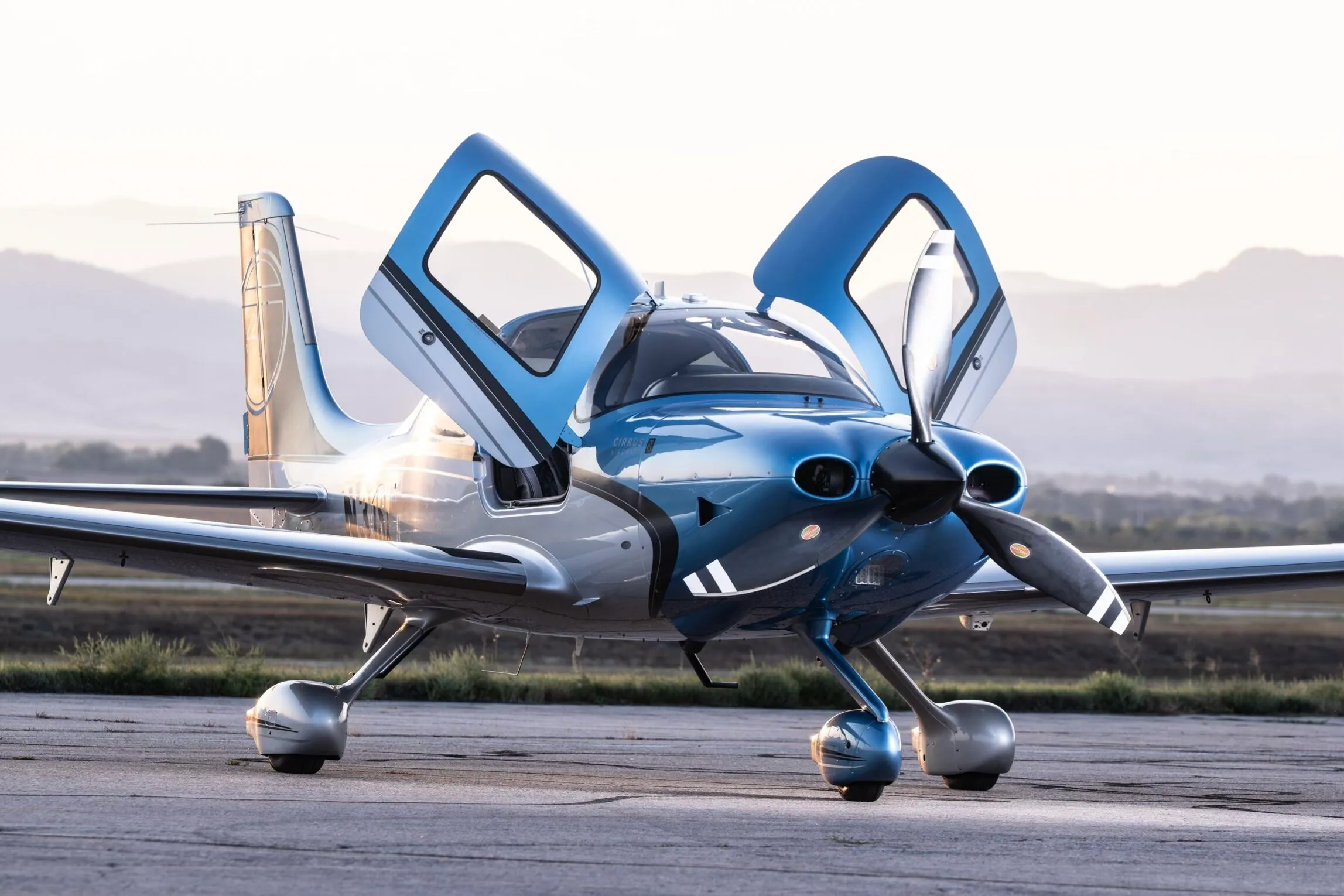 A single-engine aircraft on the ramp in golden-hour light